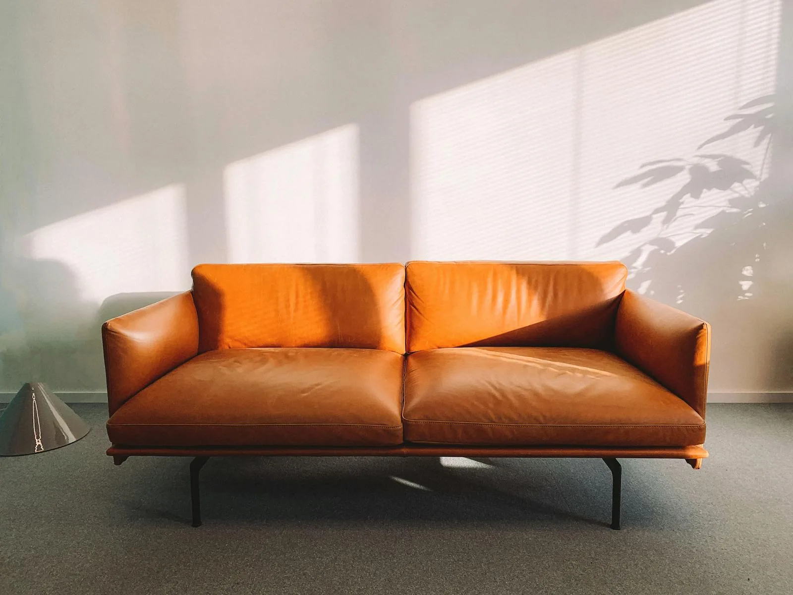 Minimalist orange leather sofa in bright room