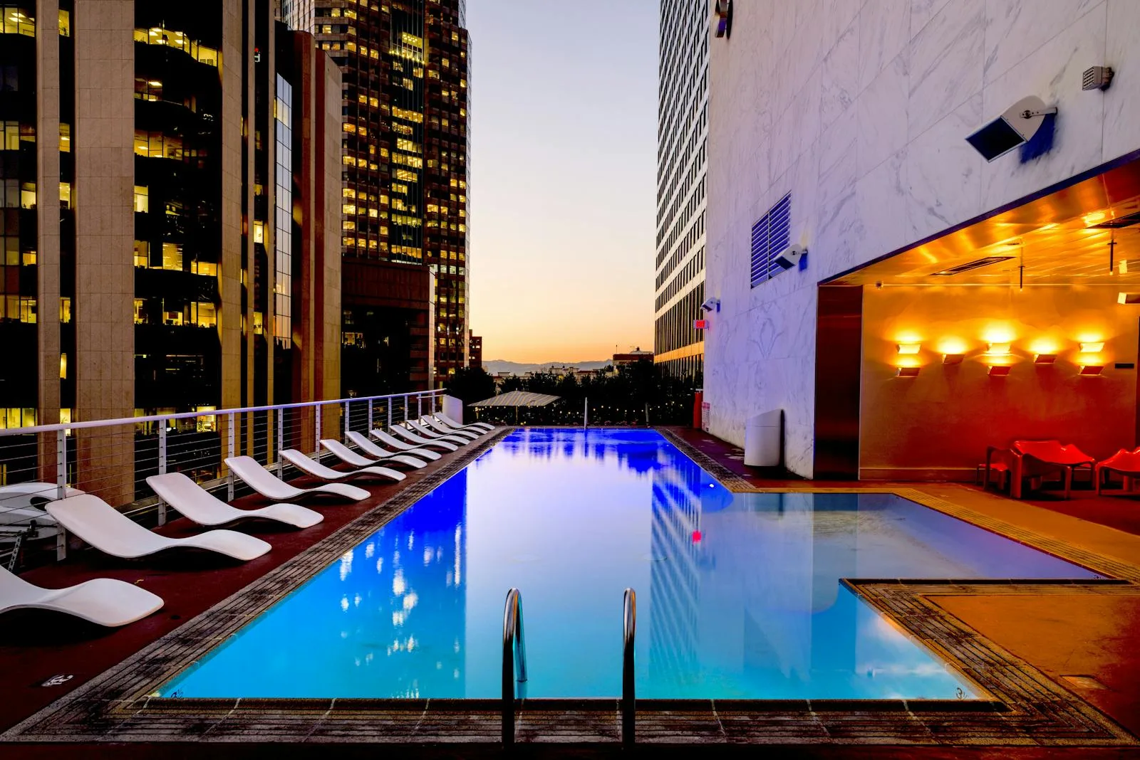 Rooftop pool with city skyline at dusk
