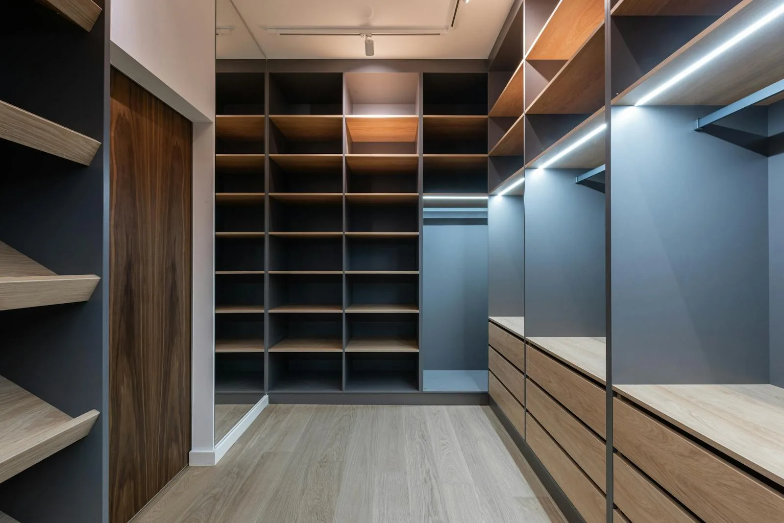Walk-in closet with wood and dark cabinetry